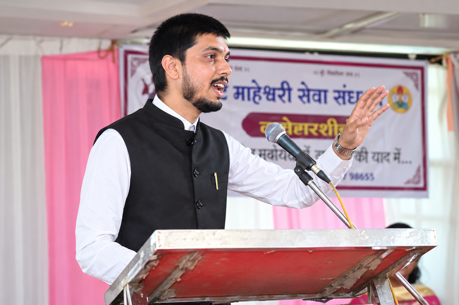 Advocate Dev Kella speaking at a cultural and community event