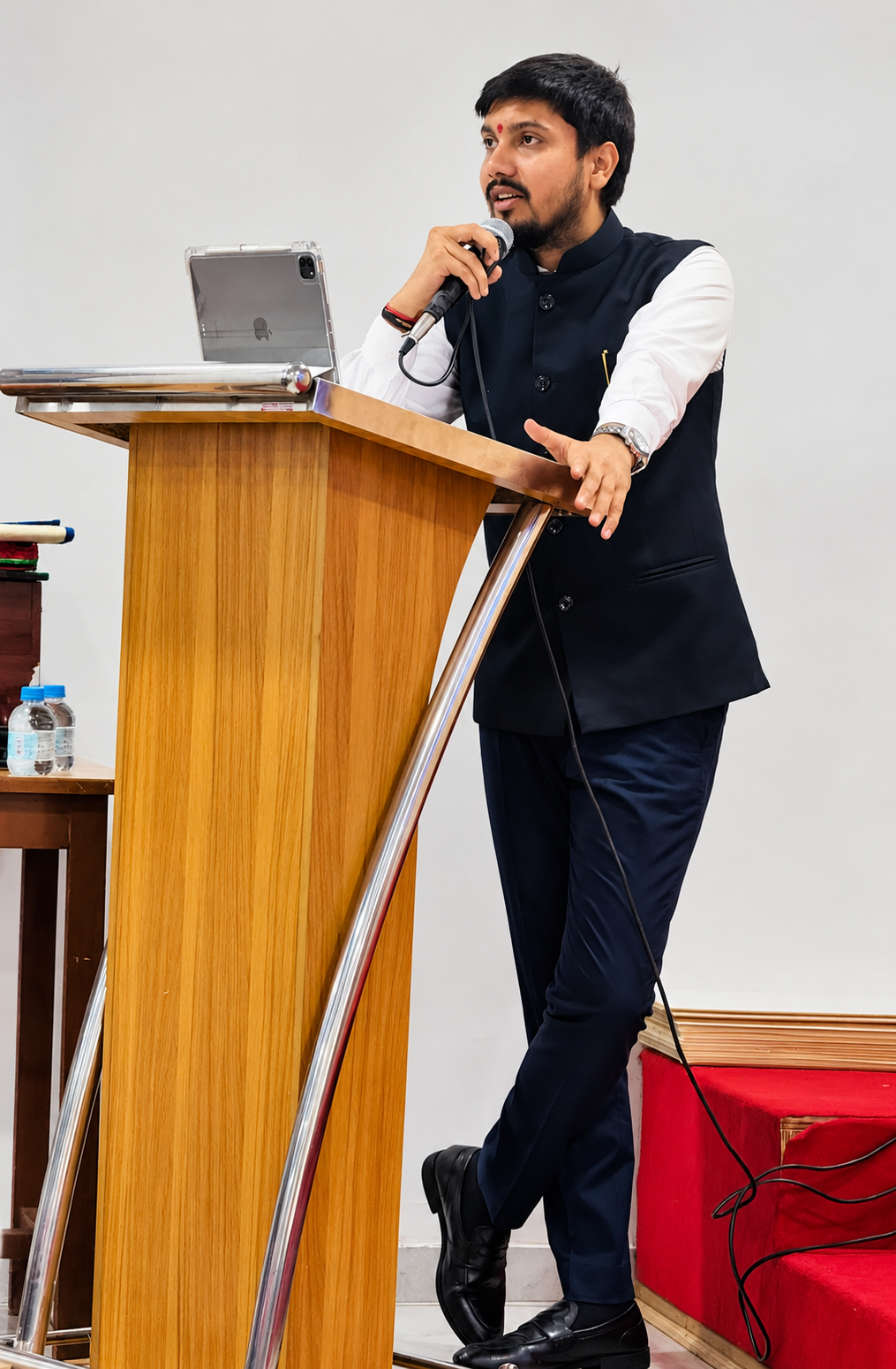 Advocate Dev Kella addressing an audience from a lectern